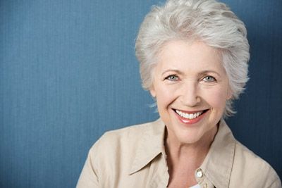 woman smiling after dental implants helped restore her smile
