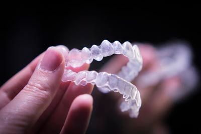 patient holding their Invisalign clear aligners