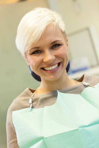 woman smiling after a successful oral surgery procedure at Bonham Dental Arts