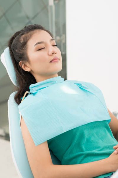 woman asleep during a dental procedure thanks to sedation